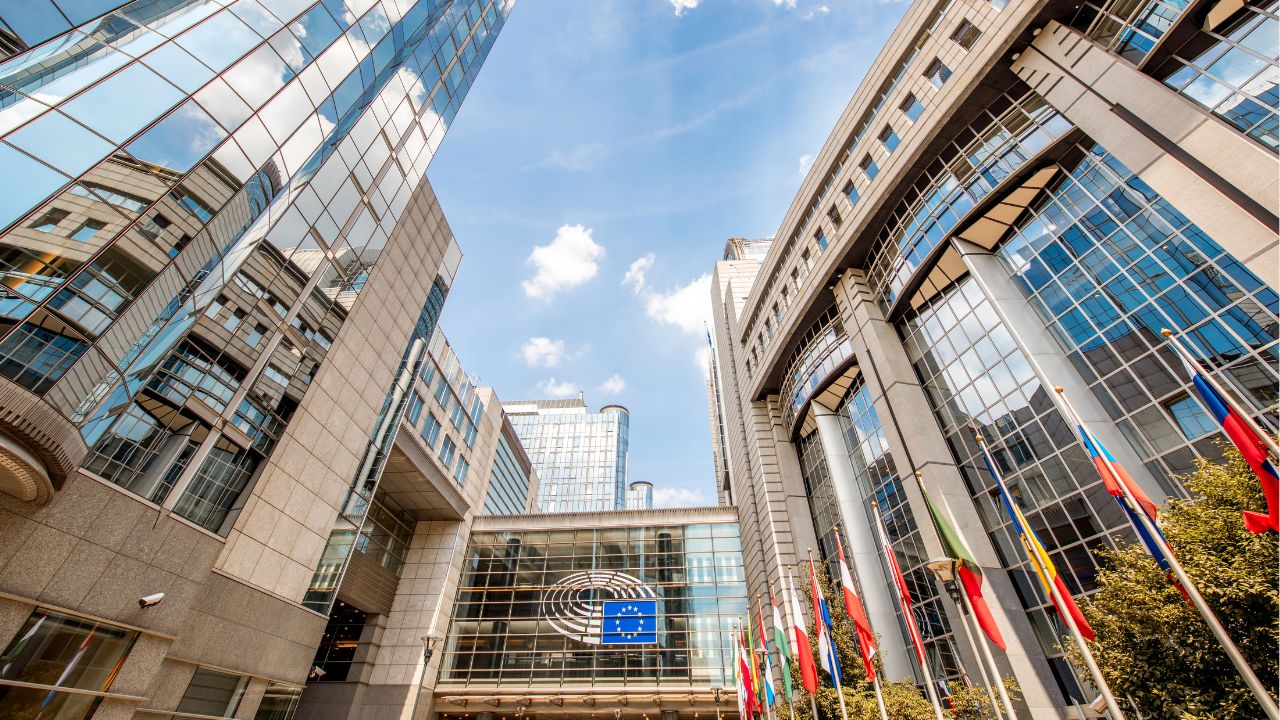 Blick auf Europaparlamentsgebäude vor dessen Eingang himmelwärts.