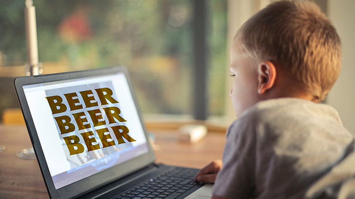 Junge vor Laptop, auf dem dreimal Bier steht