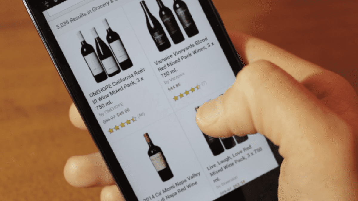 Hand hält Smartphone mit Alkohol-Lieferapp