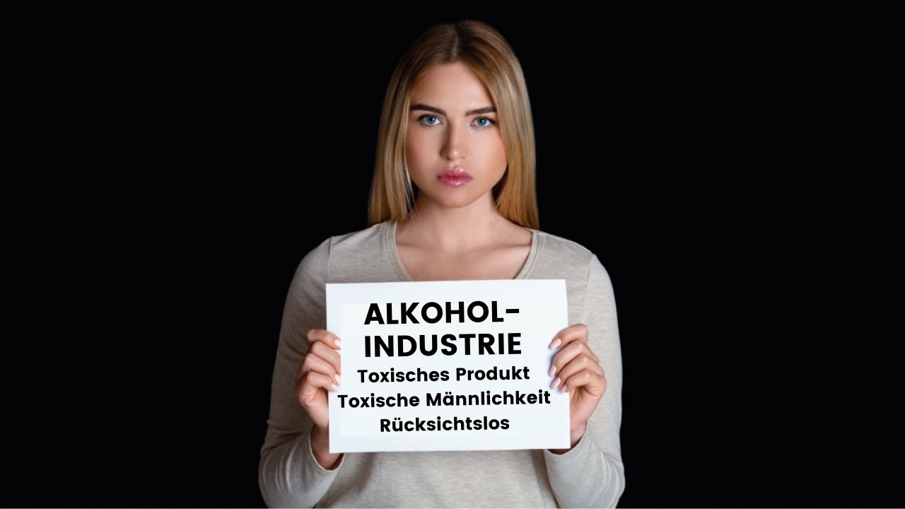 Junge Frau hält ein Schild mit der Aufschrift 'Alkoholindustrie: Toxisches Produkt, toxische Männlichkeit, rücksichtslos' vor die Brust.