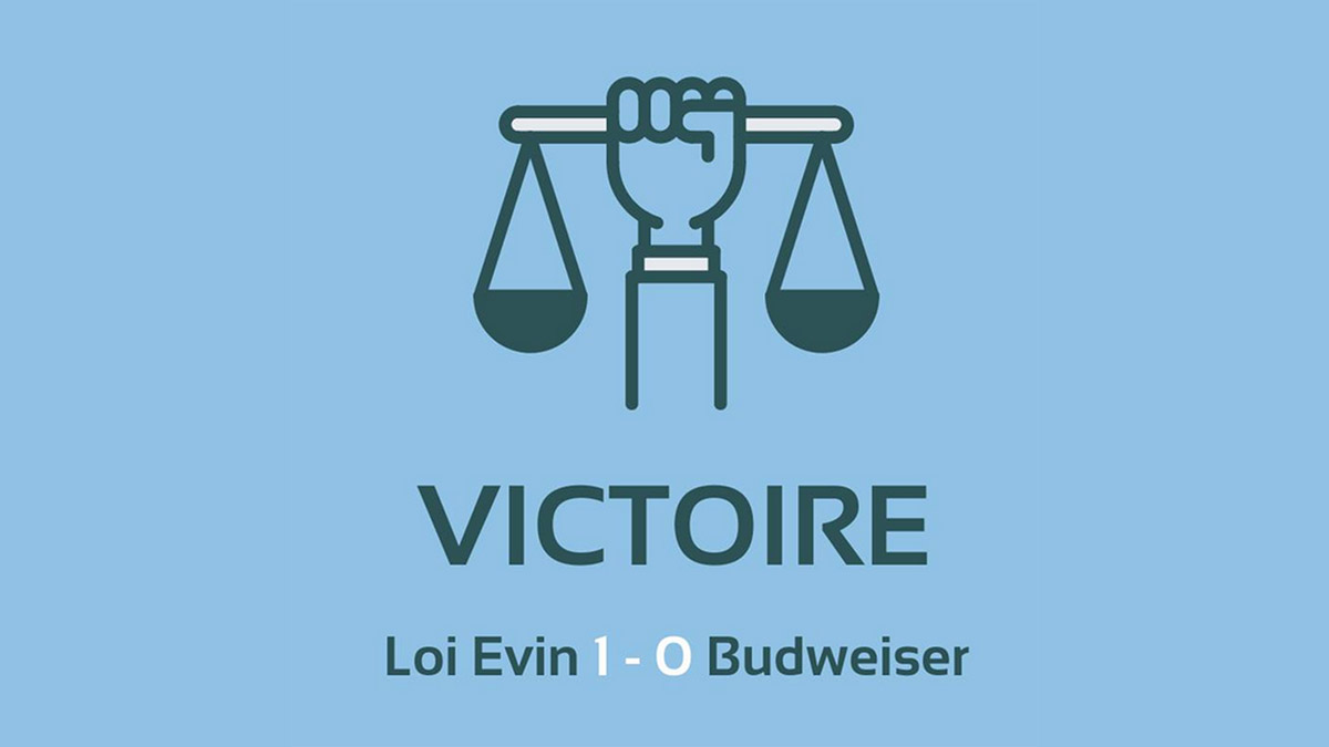Faust hält Justizwaage empor. Darunter Text 'Sieg: 1:0 für Evin-Gesetz gegen Budweiser' in frnazösischer Sprache
