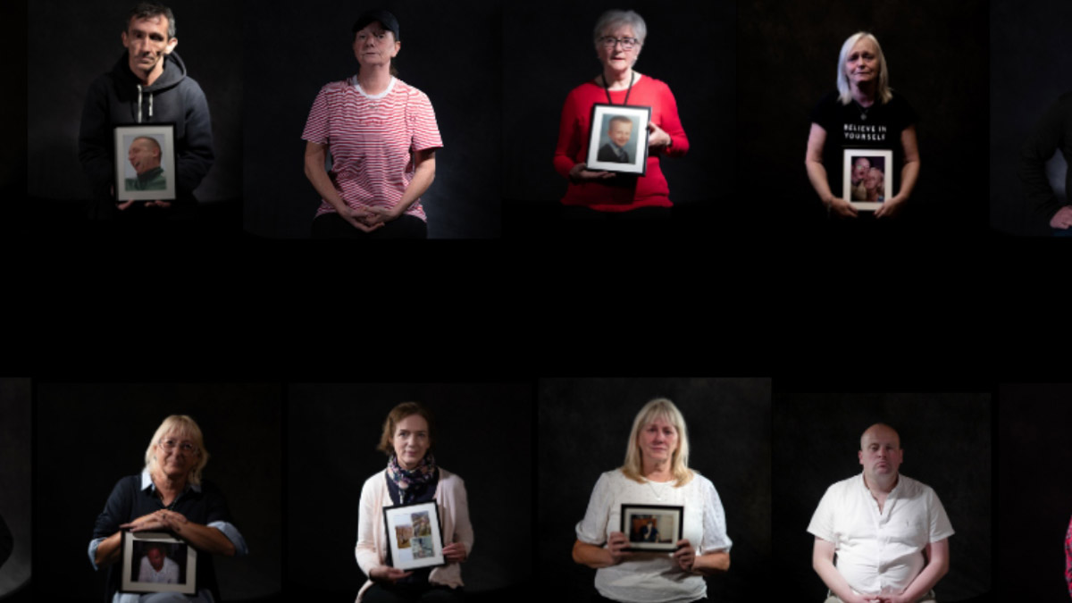 Acht Teilnehmer*innen an der Kampagne 'See Beyond - See the Lives - Scotland', von denen sechs ein Foto ihres verstorbenen Familienmitglieds vor sich halten.