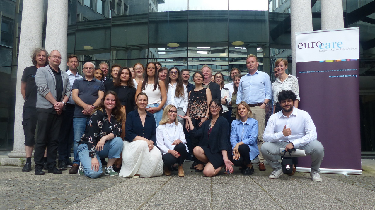 Teilnehmer*innen der Eurocare-Mitgliederversammlung sind zum Gruppenbild aufgestellt vor dem Eingang des Impact Hub in Ljubljana.