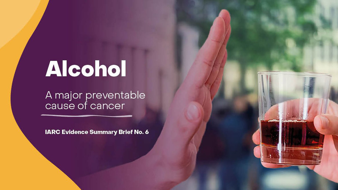 Eine Grafik mit der Überschrift 'Alkohol: Eine große vermeidbare Ursache für Krebs'. Eine Hand macht eine Stopp-Geste vor einem Glas mit einer bernsteinfarbenen Flüssigkeit, das von einer anderen Person gehalten wird. Darunter steht 'IARC Evidence Summary Brief No. 6'.