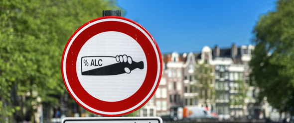 Alkohol-Verbot auf Verkehrsschild vor Stadtkulisse