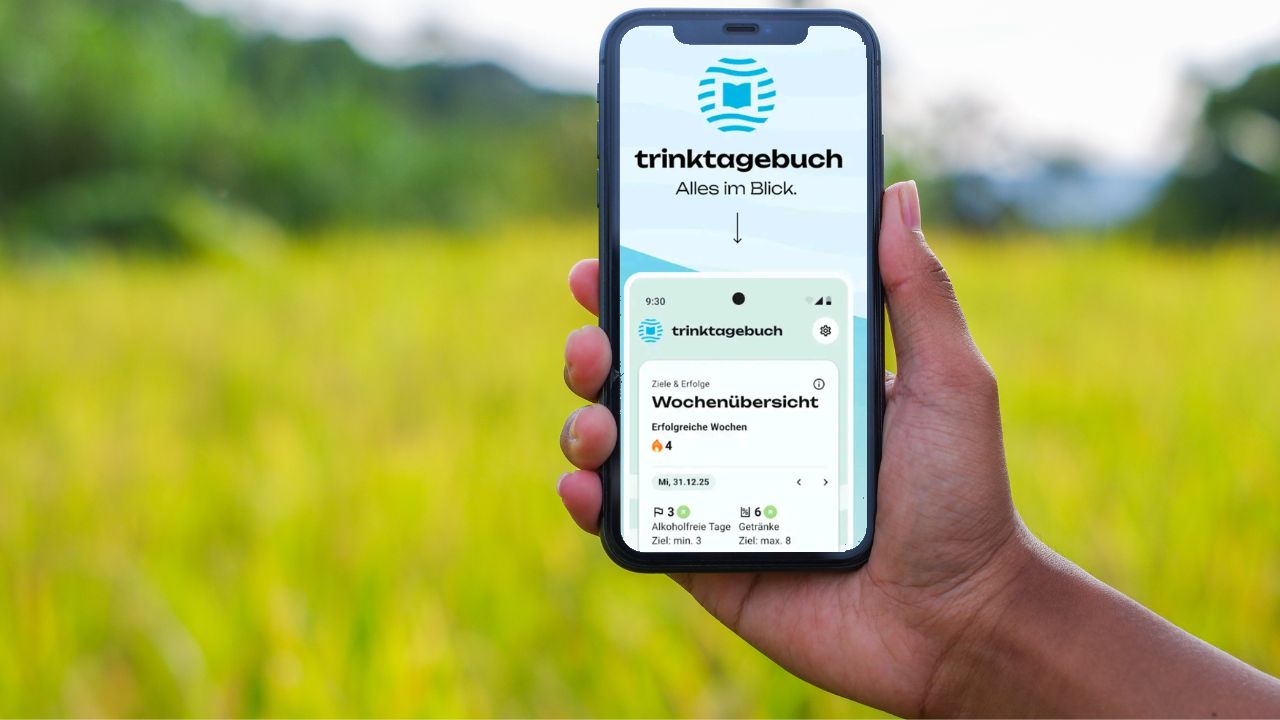 Hand hält ein Smartphone mit der Alkohol-Trinktagebuch-App in einer sonnigen Wiesenlandschaft. Auf dem Display ist die Wochenübersicht mit 3,0 Litern Flüssigkeitsaufnahme zu sehen.