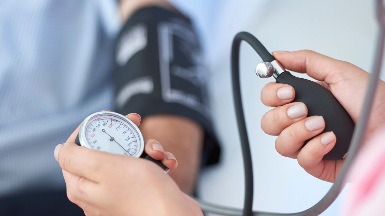 Hände einer Ärztin halten Gerät zur Blutdruckmessung.