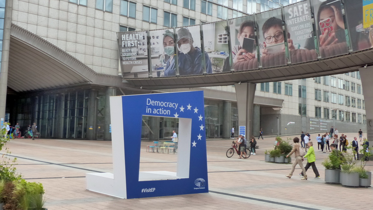 Luxemburgplatz vor dem Europäischen Parlament. Auf EU-Werbebannern sind Motive zu den Themen 'Gesundheit zuerst' und 'Sicheres Internet für Kinder' zu sehen.