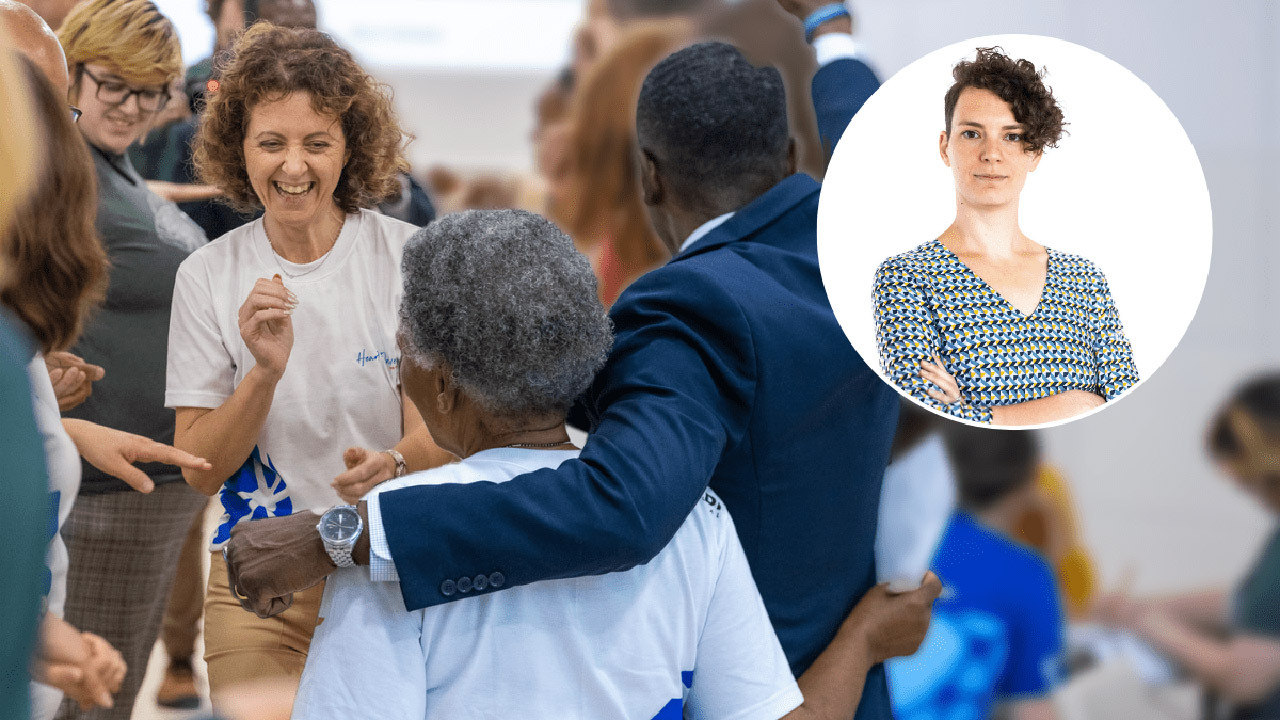 Gruppe von Menschen, die sich fröhlich begrüßen und umarmen, im Vordergrund eine lächelnde Frau mit lockigem Haar; ein Mann in dunklem Anzug legt seinen Arm um eine andere Person. Oben rechts befindet sich eine kreisrunde Einblendung mit einem Porträt einer selbstbewusst blickenden Frau mit kurzem, lockigem Haar und gemustertem Oberteil: die Autorin des Beitrags, Kristína Šperková.