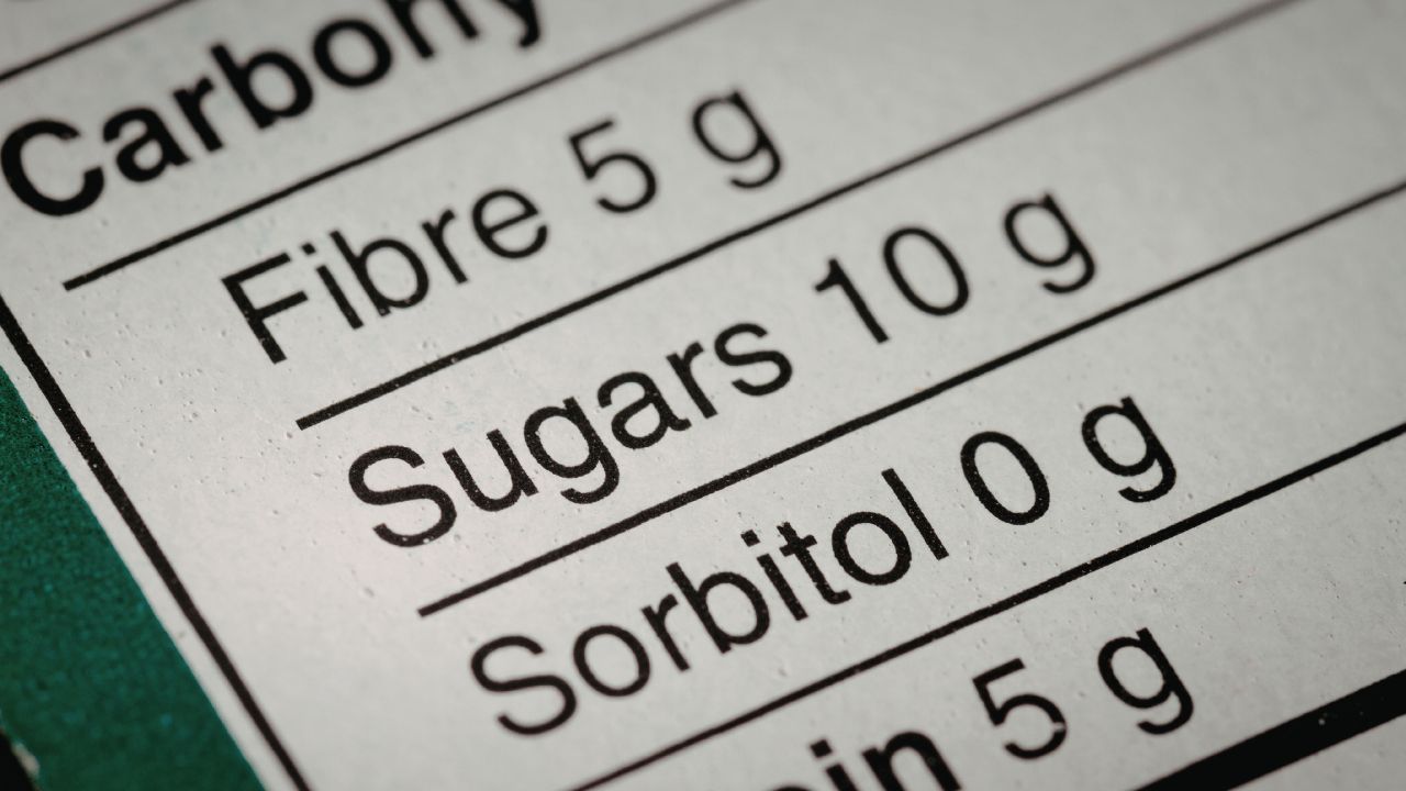 Nahaufnahme einer englischen Nährwerttabelle auf einer Verpackung, die Fibre 5 g, Sugars 10 g und Sorbitol 0 g auflistet.