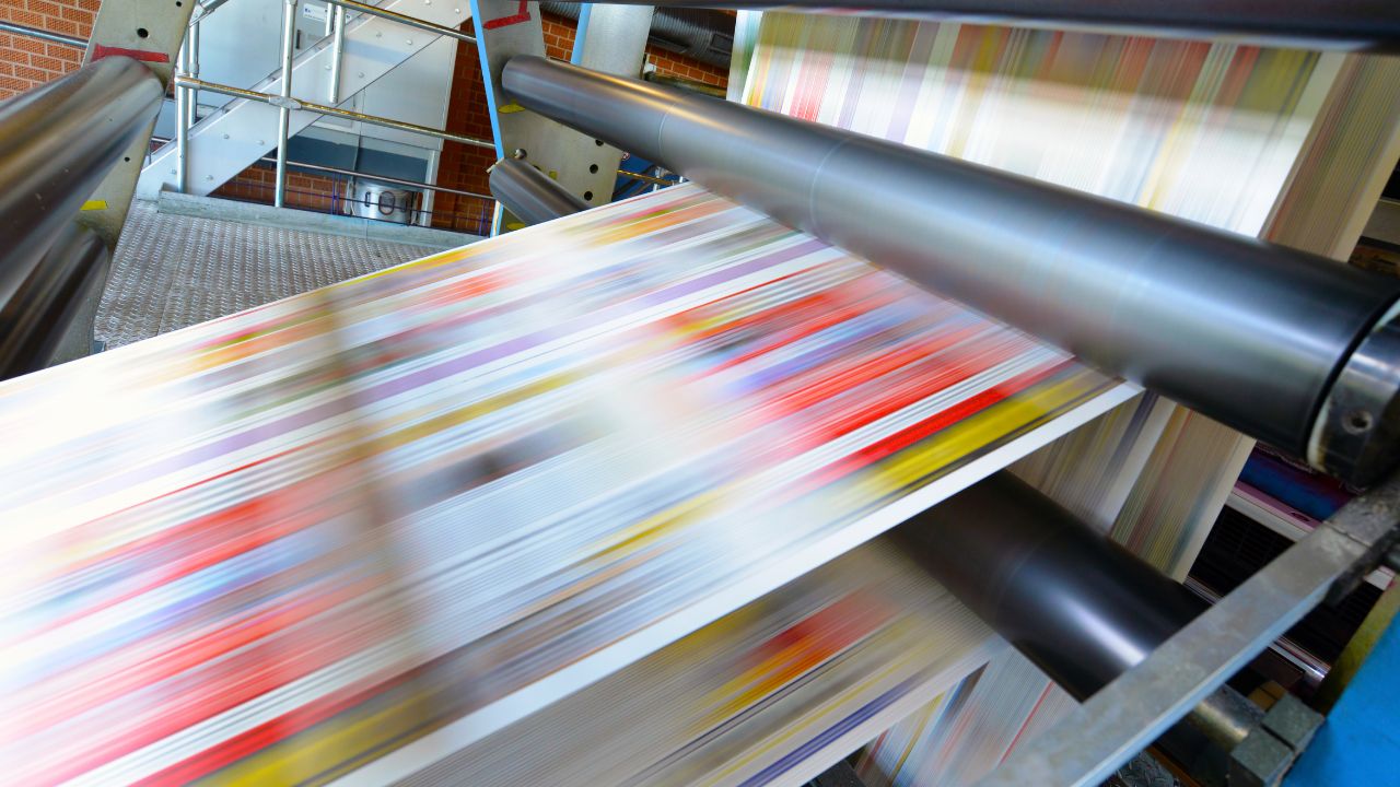 Druck von farbigen Zeitungen mit einer Offsetdruckmaschine in einer Druckerei.