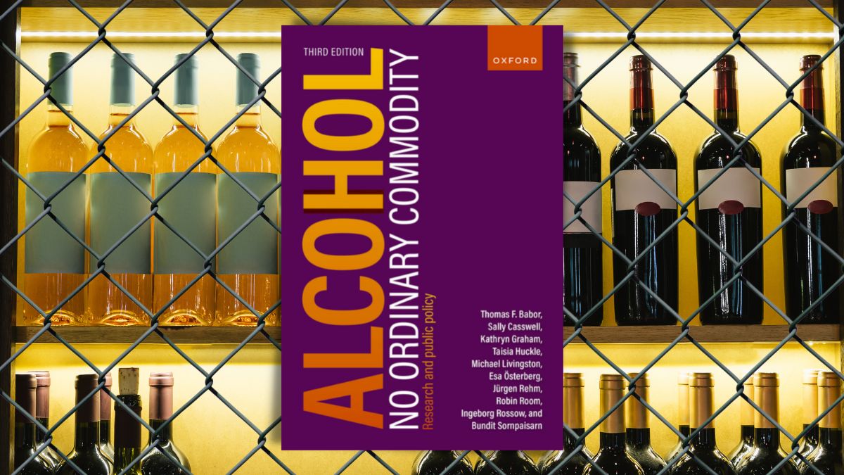 Buchtitel 'Alcohol - No ordinary commodity' vor Weinregal hinter Maschendraht
